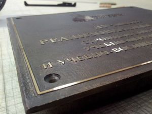 Латунная табличка с гравировкой и старением фона Латунная табличка с гравировкой и старением фона